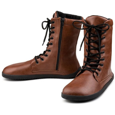 A photo of Ahinsa Jaya boots made from faux leather and rubber soles. The boots are brown in color the fit is mid calf and they have laces all the way up. Both boots are shown beside each other slightly spaced out and facing opposite directions against a white background. #color_brown