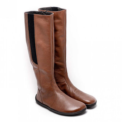 A photo of Belenka Sierra made from smooth leather, fleece, and rubber soles. The boots are brown in color with a tall riding boot elastic paneled shaft lined with fleece. Both both are shown beside each other from the right side angled slightly to the front against a white background. #color_brown