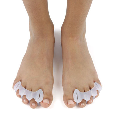 A photo of correct toes clear toe spacers made from silicone. A woman’s feet are shown wearing the correct toes and facing towards the front against a white background. 