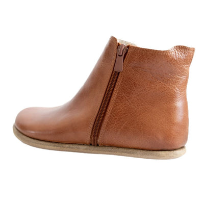 A photo of designed by Anya Rosa boots made from leather and rubber soles. The boots are brown in color, they are a Chelsea boot style with a zipper on the sides. One boot is shown from the left side against a white background. #color_brown