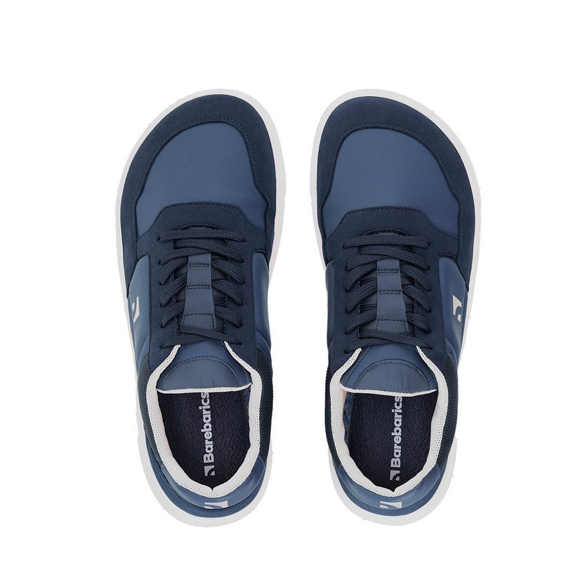 Photo 1 - A photo of Barebarics Axiom sneakers. The sneakers are made with a dark blue tent-like fabric with suede-like material borders around the toe box, laces, ankle, and heel. The rubber sole is white and there is a logo on the wide of the shoe. Left sneaker is shown here from the right side against a white background., Photo 2 - Both shoes are shown from the top down against a white background. #color_dark-blue-white