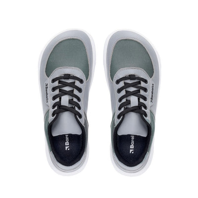 Photo 1 - A photo of Barebarics Bravo sneakers. The sneakers are made with white rubber soles and grey textile fabric topped with lighter grey leather borders around the toe box, laces, and heel. Laces are black. Right sneaker is shown here from the right side against a white background., Photo 2 - Both shoes are shown from the top down against a white background. #color_grey-white