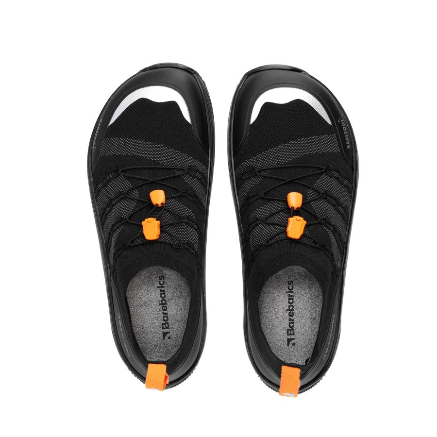 Photo 1 - A photo of Barebarics Voyager active sneakers. The sneakers are made with a black sock-like stretch fabric with black protector fabric around the front and back of the shoe. Interwoven black strings on either side hold the black elastic quick laces in place. Right sneaker is shown here from the right side against a white background., Photo 2 - Both shoes are shown from the top down against a white background. #color_black