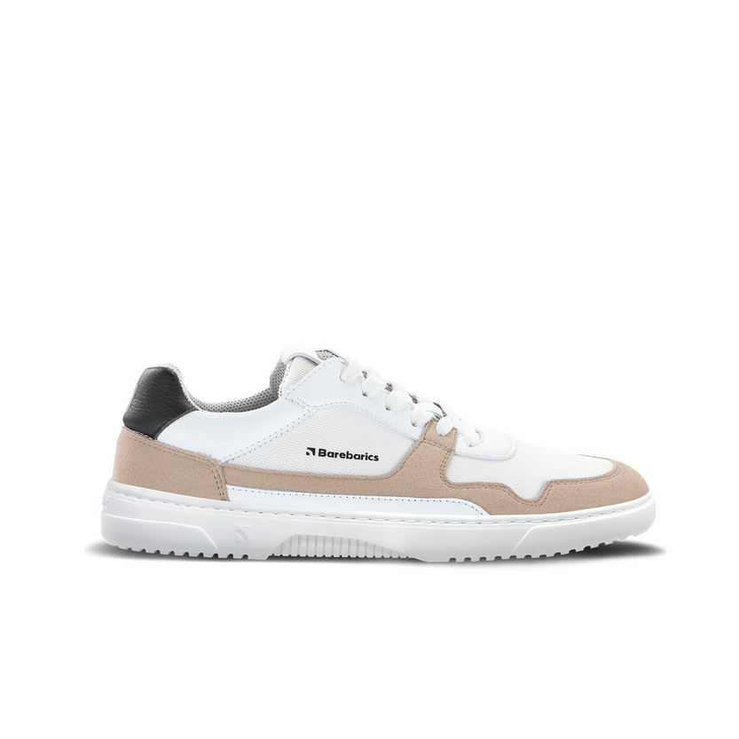 A photo of Barebarics Zing sneakers made with a leather upper and a rubber sole. The sneakers are a white and beige color with perforated spots on the top of the toe box and barebarics branding on the tongue and side. They also have black at the top of the heel. The left sneaker is shown from the side against a white background. #color_white-beige