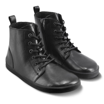 A photo of Be Lenka Atlas ankle zip up boots made from smooth leather and rubber soles. The boots are black in color with black laces, zippers, a pull tab in the back, and lined with felt. Both boots are shown diagonally from the right side against a white background. #color_black