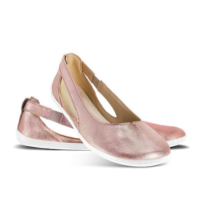 A photo of Rose Gold Be Lenka Bellissima 2.0 flats with a leather upper and rubber soles. The flats are a black color with a small stitching V detail in the front and a cut out design on the sides. Both flats are shown facing right the right flat is in front with its heel leaning on the left shoe against a white background. #color_rose-gold