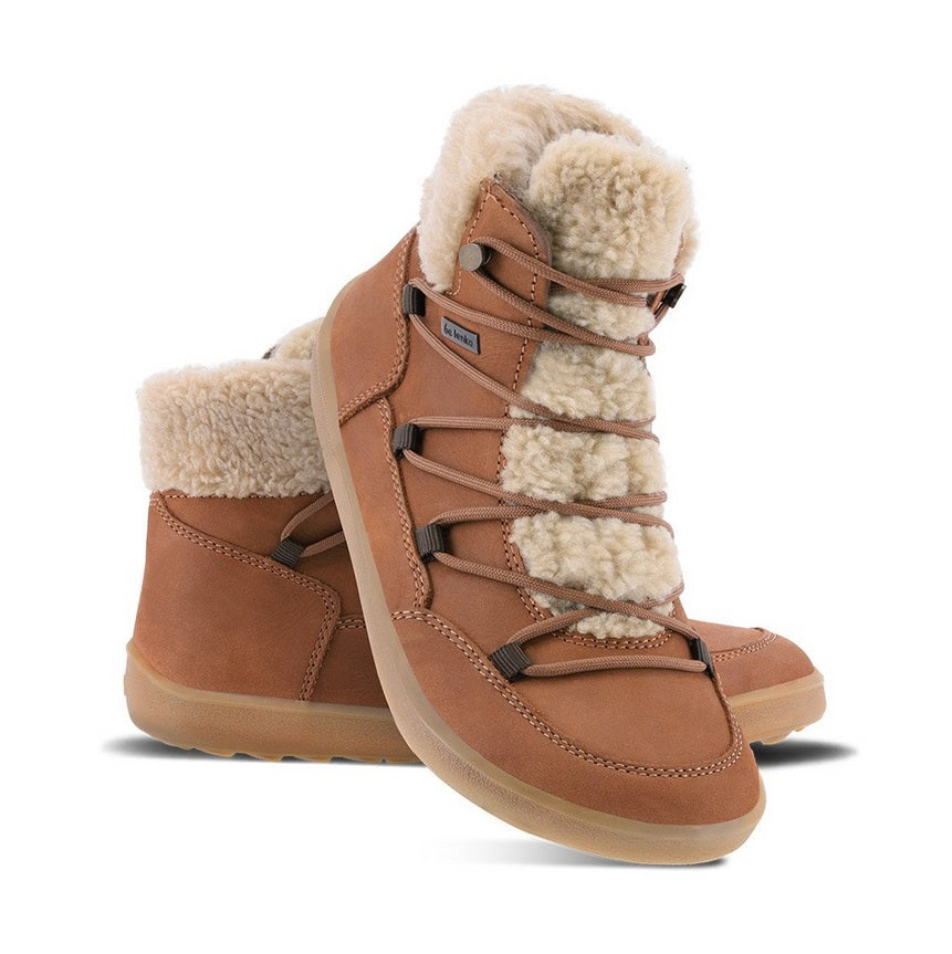 A photo of Belenka Bliss Boots made from nubuck leather and tan rubber soles. The boots are brown in color, have a fleece tongue and around the top. The laces are wide across the boot top and have speed hooks at the by the top. Both shoes are shown the left shoe is sitting behind the right shoe, the right shoes heel is leaning on the left shoe and is facing downward against a white background. #color_brown
