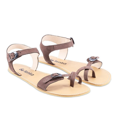 Photo 1 - Be Lenka Claire leather sandals in chocolate. Sandals have an open heel ankle strap that closes with a silver buckle, and connects to both sides of the sole. A criss-cross toe strap is featured at the big toe with a silver buckle connecting a thin toe strap to a thicker strap on the outside. Shoes are shown diagonally from the right side with a white background., Photo 2 - Both shoes are shown from the top down against a white background. #color_chocolate