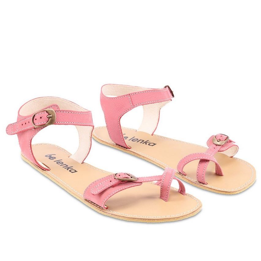 Photo 1 - Be Lenka Claire leather sandals in flamingo pink. Sandals have an open heel ankle strap that fascines with a gold buckle, and connects to both sides of the sole. A criss-cross toe strap is featured at the big toe with a gold buckle connecting a thin toe strap to a thicker strap on the outside. Shoes are shown diagonally from the right side with a white background., Photo 2 - Both shoes are shown from the top down against a white background. #color_flamingo-pink