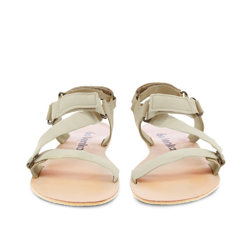 A photo of Beige Green Be Lenka Flexi Sandals made with fabric straps with velcro and a tan leather topped rubber soles. The sandals are a light beige green color and have straps that cross the front of the foot and continue around the mid-foot, ankle, and heel. Both sandals are shown from the front beside each other against a white background in this photo. #color_beige-green