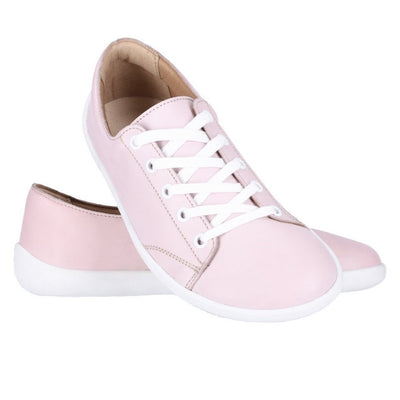 A photo of Light Pink Be Lenka Prime 2.0 Simple Leather Sneakers with white soles. Left shoe is shown from the right with the right shoe propped up on the left to show the top of the shoe. Background is white. #color_light-pink
