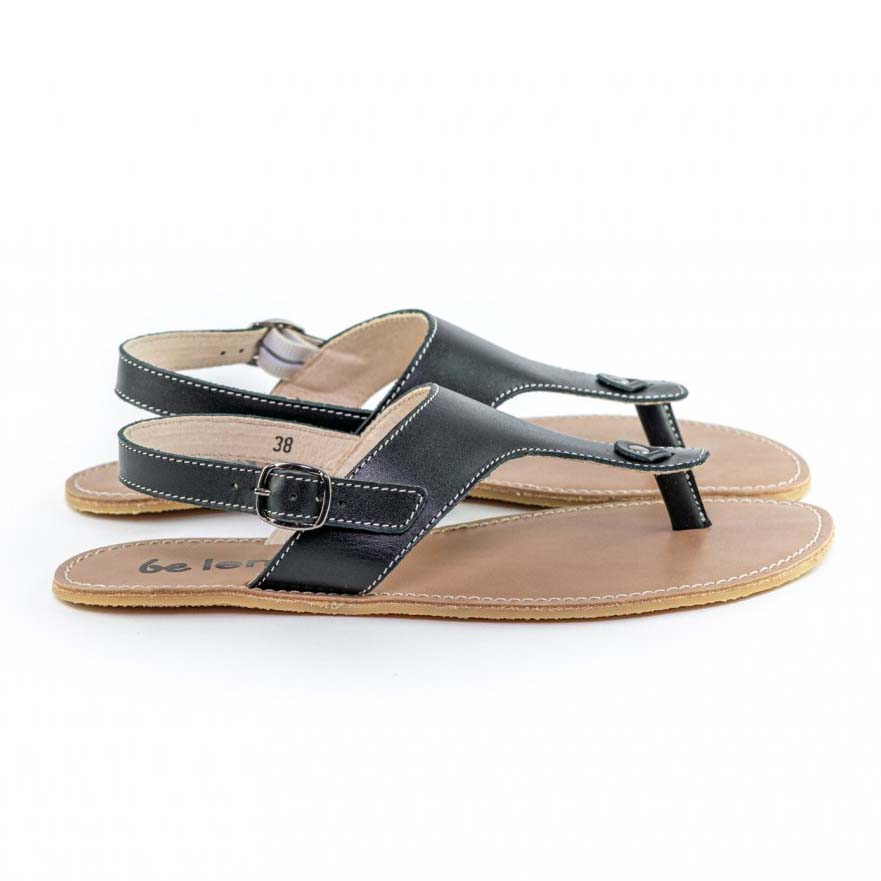 A photo of Black Be Lenka Promenade Sandals made with leather and tan rubber soles. The sandals have black thong straps and a heel strap with a buckle. Both sandals are shown from the right side against a white background in this photo. #color_black