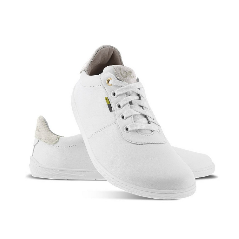 A photo of white Be Lenka Royale Sneakers with beige accents on the top of the tongue and heel cup. Left shoe is shown from the right with the right shoe propped up on the left to show the top of the shoe. Background is white. #color_white-beige