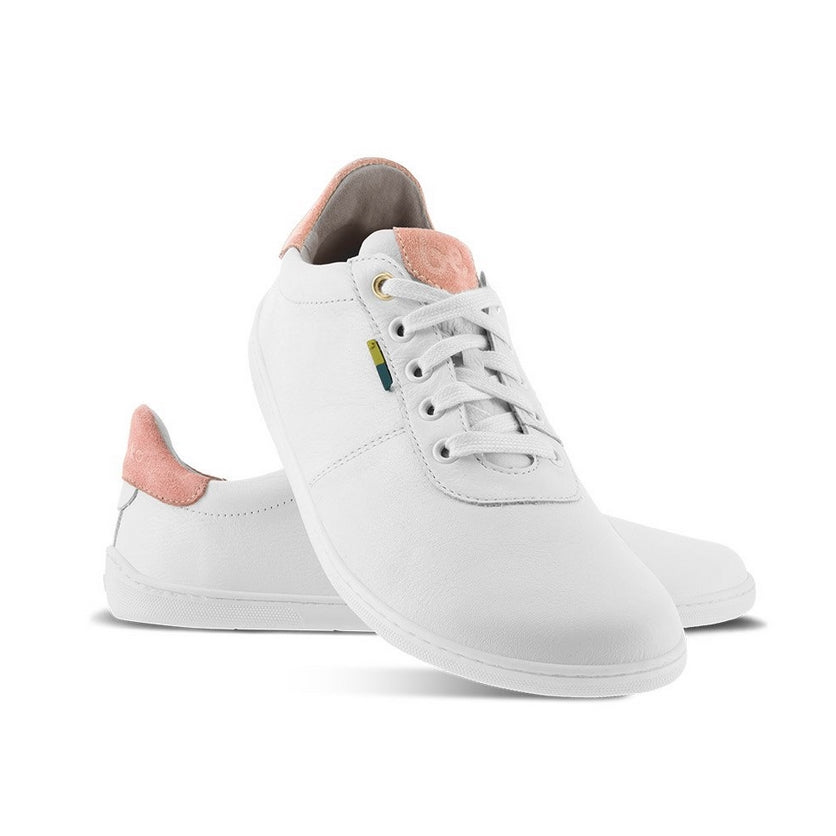 A photo of white Be Lenka Royale Sneakers with dark peach accents on the top of the tongue and heel cup. Left shoe is shown from the right with the right shoe propped up on the left to show the top of the shoe. Background is white. #color_white-dark-peach