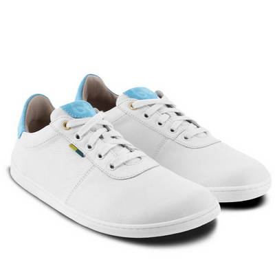 A photo of Be Lenka Royale sneakers made with a leather upper and a rubber sole. The sneakers are a white color and the area around the heel is light blue, they have small yellow and blue tag on the side. Both sneakers are shown beside each other angled from the right side against a white background. #color_white-blue
