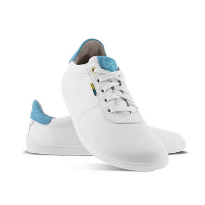 A photo of Be Lenka Royale sneakers made with a leather upper and a rubber sole. The sneakers are a white color and the area around the heel is light blue, they have small yellow and blue tag on the side. Both shoes are shown, the left shoe is behind the right. The right shoes heel is leaning up against the left shoe showing the right shoe from the front facing down against a white background. #color_white-blue