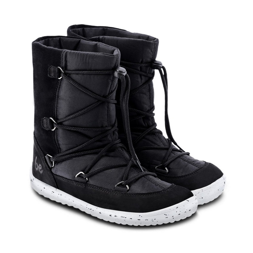 A photo of Be Lenka Kids Snowfox boots in black. Black suede and textile and light grey soles surround the outside. Black laces are widely connected from side to side starting at the ball of the foot and going until the top of the boot with a quick lace connector securing the laces in place. Both shoes are shown diagonally from the front right side against a white background. #color_black