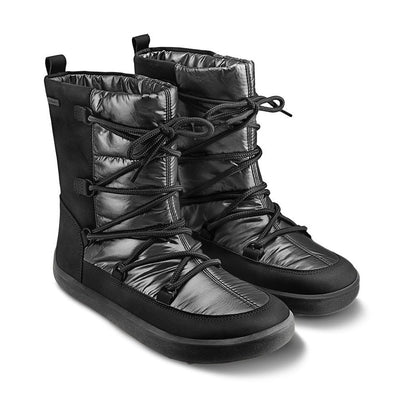 A photo of Be Lenka Adult Snowfox boots in all black. Black leather goes around the back with black satin over the top and front, and black soles. Laces are widely connected from side to side starting at the ball of the foot and going until the top of the boot. Both shoes are shown diagonally from the front right against a white background. #color_black