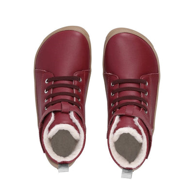 Photo 1 - A photo of Be Lenka Winter Kids boots in Dark Cherry Red with gum soles. Boots are slightly above ankle height, have elastic laces, and a velcro ankle strap closure. Right shoe is shown from the right side against a white background. Photo 2 - Both shoes are shown from the top down against a white background. #color_dark-cherry-red