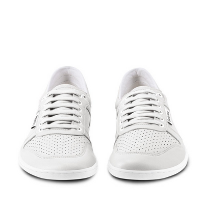 A photo of Belenka Champ sneakers made from leather and rubber soles. The sneakers are white in color with perforation on the toe box and detail stitching. Both shoes are shown beside each other from the front against a white background. #color_white