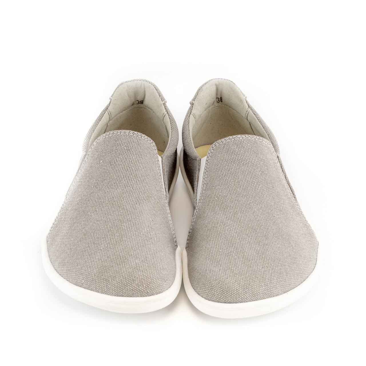 A photo of Belenka Eazy slip-on sneakers made from canvas and rubber soles. The sneakers are a sand color with white elastic on the sides and soles. Both shoes are shown from the front against a white background. #color_sand