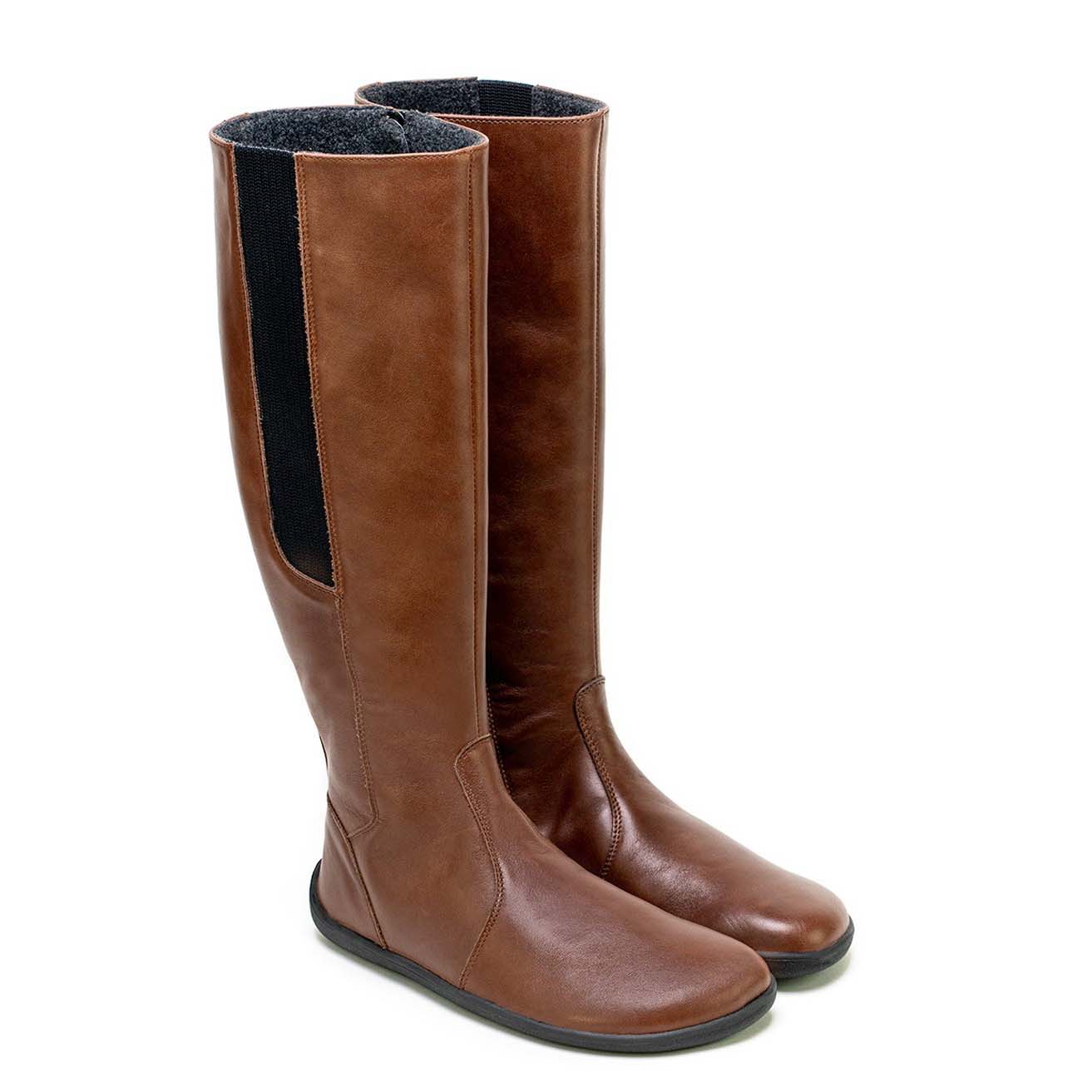 A photo of Belenka Sierra made from smooth leather, fleece, and rubber soles. The boots are brown in color with a tall riding boot elastic paneled shaft lined with fleece. Both both are shown beside each other from the right side angled slightly to the front against a white background. #color_dark-brown