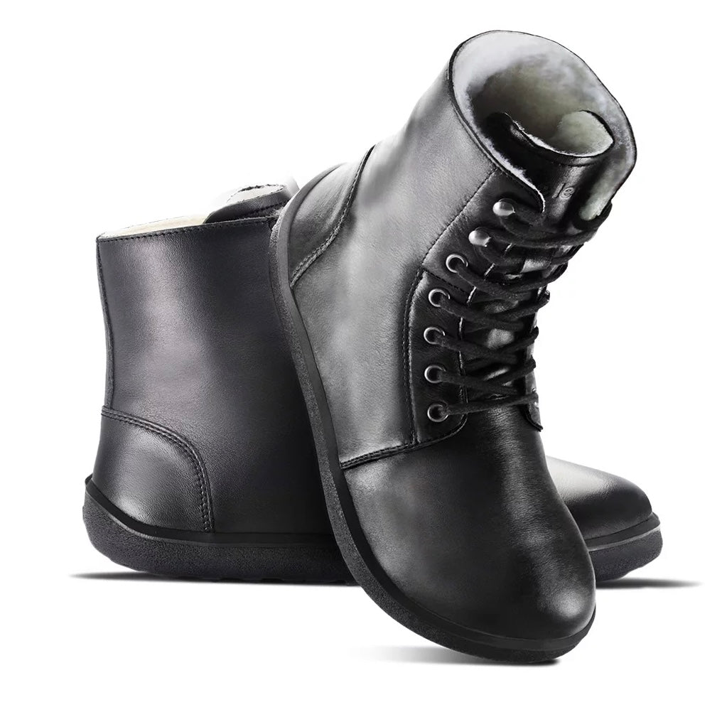 A photo of Be Lenka Winter Neo boots made with leather and rubber soles. The boots are black in color and a lace up style with wool inside. Both boots are shown beside each other from the right side, the right boot’s heel is leaning on against the left boot against a white background. #color_black-smooth-leather
