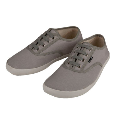 A photo of Bohempia Kolda Plimsole sneakers made from canvas and rubber soles. The sneakers are grey in color with trim detailing and a small tag on the top by the laces. Both shoes are shown beside each other facing toward the left against a white background. #color_grey