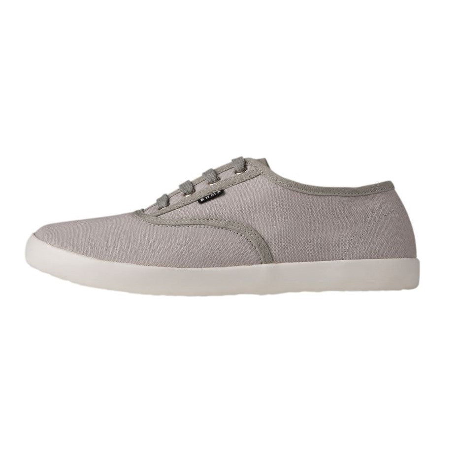 A photo of Bohempia Kolda Plimsole sneakers made from canvas and rubber soles. The sneakers are grey in color with trim detailing and a small tag on the top by the laces. The left shoe is show from the left side against a white background. #color_grey