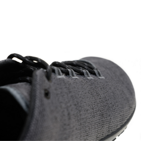 A photo of Freet Pace sneakers in charcoal. Sneakers are completely knit and have a detatched tongue. Laces are black and loop through fabric tabs attached to the shoe and a tab on the tongue. The right shoe is shown here diagonally from the back right against a white background. #color_charcoal