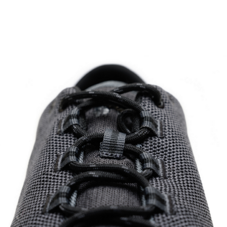 A photo of Freet Pace sneakers in charcoal. Sneakers are completely knit and have a detatched tongue. Laces are black and loop through fabric tabs attached to the shoe and a tab on the tongue. The right shoe is shown here from the front laces against a white background. #color_charcoal