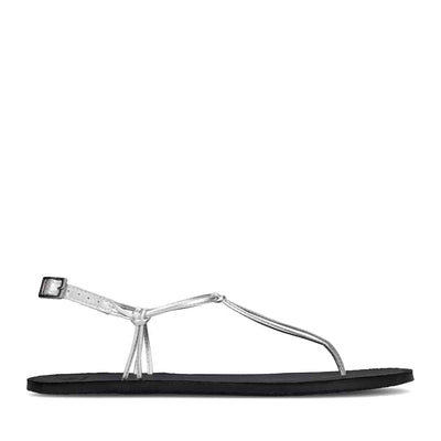 Photo 1 - A photo Groundies Amalfi sandals with black soles and silver straps. A thong strap extends from the toes to a delicate buckle closure ankle strap which is anchored to the sole by thin straps on both sides. Right shoe is shown from the right side against a white background. Photo 2 - Left shoe is shown floating diagonally from the front left side against a white background. #color_silver