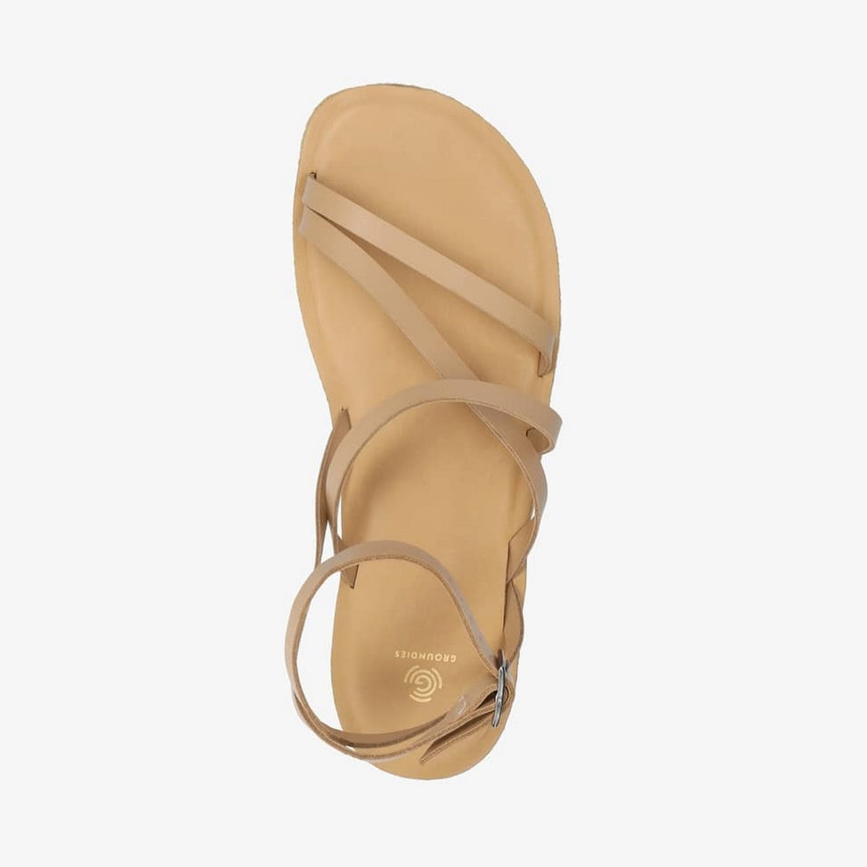 A photo of beige leather Groundies Florence Sandals. Two leather straps start at the ball of the big toe with one ending at the ball of the little toe and the other midfoot. Another strap goes from one side of the heel over the top of the foot to the other side with one final strap wrapping around the ankle and closing with a buckle. Right shoe is shown from the top down against a white background. #color_beige