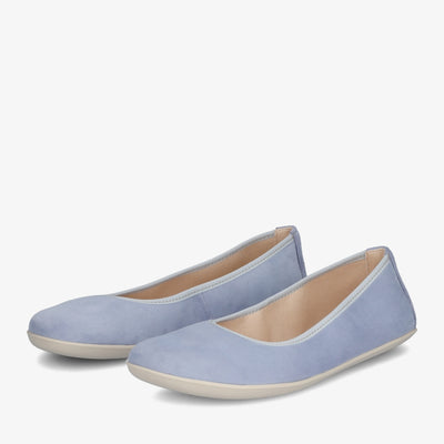 A photo of Groundies Lily Soft flats with a leather upper and cream rubber true sense soles. The flats are a nubuck in a light blue color, the trim around the tops of the flats is a baby blue color and is lighter than the rest of the flats. The interior of the flats is a light beige color. Both flats are shown beside each other facing to the left with the left flat on the outside against a white background. #color_light-blue