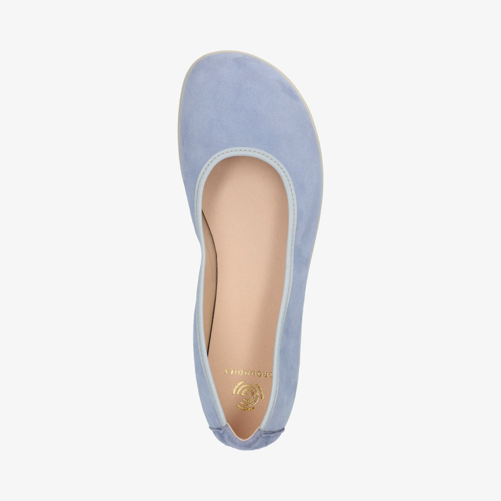 A photo of Groundies Lily Soft flats with a leather upper and cream rubber true sense soles. The flats are a nubuck in a light blue color, the trim around the tops of the flats is a baby blue color and is lighter than the rest of the flats. The interior of the flats is a light beige color. The right flat is shown floating facing downwards against a white background. #color_light-blue