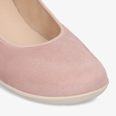 A photo of Groundies Lily Soft flats with a leather upper and cream rubber true sense soles. The flats are a nubuck in a light pink color, the trim around the tops of the flats is a light pink color that is lighter than the rest of the flats. The interior of the flats is a light beige color. The right flat is shown up close from the front angled to the right against a white background. #color_light-pink