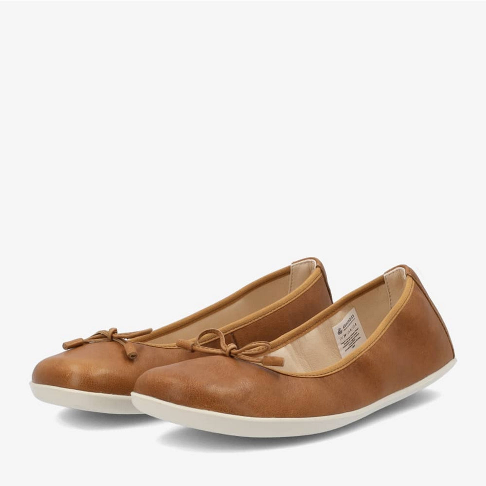 A photo of light brown leather Groundies Magnolia Flats. These classic ballet flats are simple with a leather bow located at the top of the shoe opening. Shoes are shown diagonally from the left side against a white background. #color_light-brown