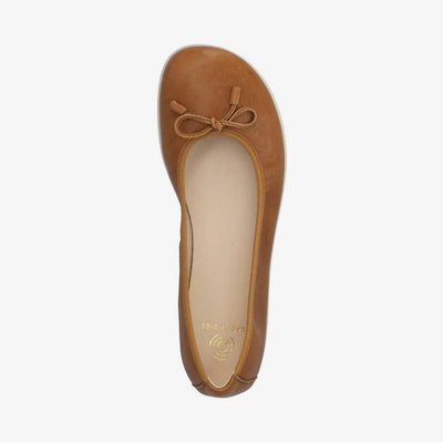A photo of light brown leather Groundies Magnolia Flats. These classic ballet flats are simple with a leather bow located at the top of the shoe opening. Right shoe is shown from the top down against a white background. #color_light-brown