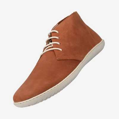 A photo of Groundies Milano an ankle high lace up made from a nubuck leather and a rubber sole. The ankle high lace ups are a cognac color with white GO1 soles and white laces. The left shoe is shown floating facing downward against a white background. #color_congac