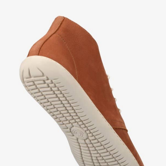 A photo of Groundies Milano an ankle high lace up made from a nubuck leather and a rubber sole. The ankle high lace ups are a cognac color with white GO1 soles and white laces. The right shoes sole is shown up close from the sole against a white background. #color_congac