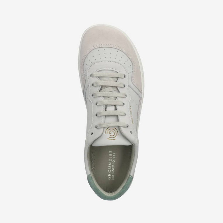 A photo of Groundies Nova sneakers made from leather and rubber soles. The sneakers are beige and white with pink/green accents on the heel, they also have perforation on the toe box. The right sneaker is shown over top facing downward against a white background. #color_beige-green-pink