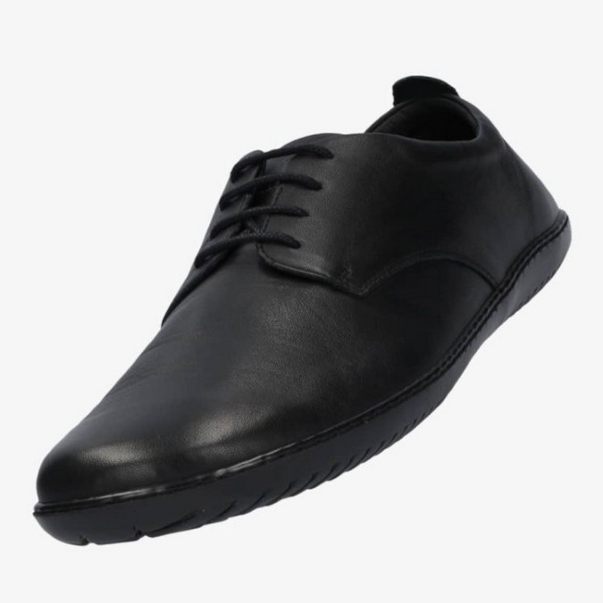 A photo of Groundies Palermo dress shoes made of leather upper and rubber soles. The shoes are a black color with black soles and dress sole detailing by the laces. The left shoe is shown floating facing downward against a white background. #color_black