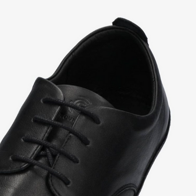 A photo of Groundies Palermo dress shoes made of leather upper and rubber soles. The shoes are a black color with black soles and dress sole detailing by the laces. One shoe is shown up close from the ankle opening of the shoe against a white background. #color_black
