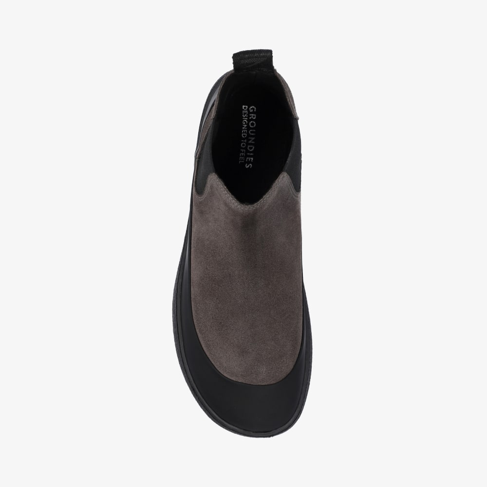 Photo 1 - A photo of Groundies ankle height Sienna chelsea boots in grey. Grey suede surrounds the outside with a black toe guard surrounding the leather around the sole. Right shoe is shown from the right side against a white background. Photo 2 - Right shoe is shown from the top down. #color_grey