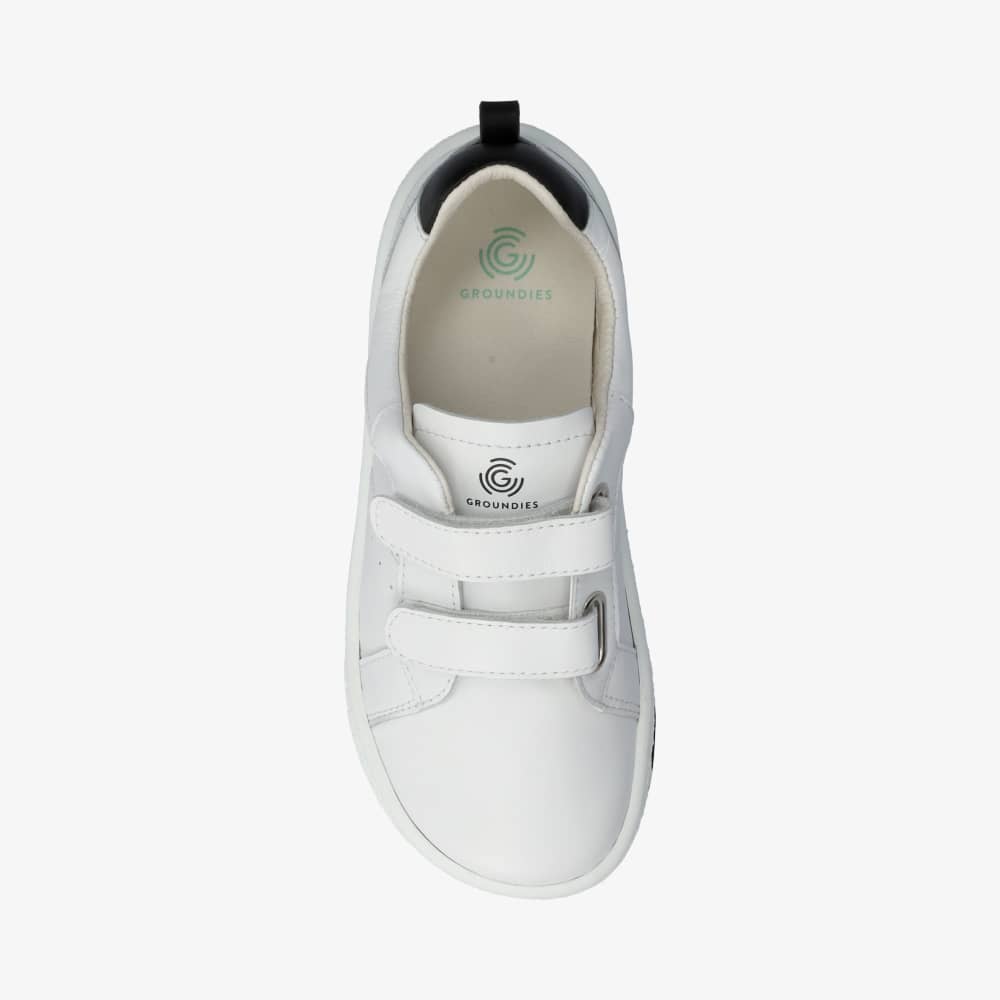 Photo 1 - A photo of white Groundies Universe shoes with classic sneaker details. The shoe is made of white leather surrounding with a black leather color block and pull tab at the top back of the heel. Right shoe is shown from the right side against a white background. Photo 2 - Right shoe is shown from the top down against a white background. #color_white-black