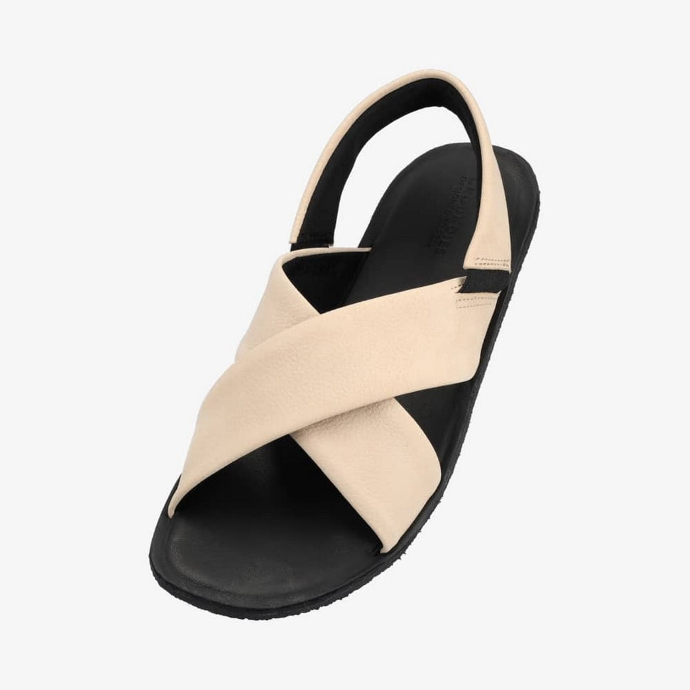 Photo 1 - A photo of Groundies Verona leather sandals in beige. Two thick straps make an X across the foot while a thinner strap keeps the sandal secure to the foot. The right shoe is shown from the right against a white background. Photo 2 - Left shoe is shown floating diagonally from the left against a white background.  #color_beige