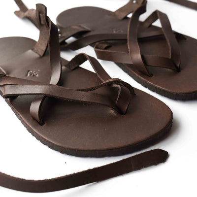 a brown leather strappy sandal shown from the front right on a white background  #color_brown