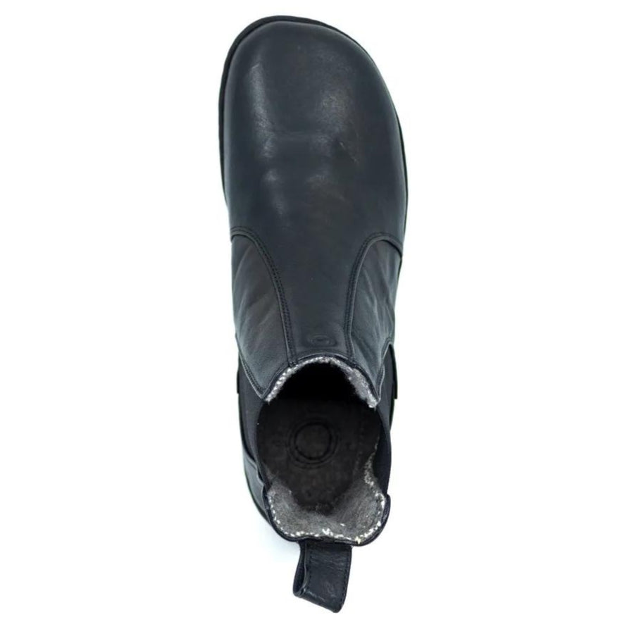 A photo of Mukishoes felted-wool-lined, leather Chelsea boots in black. Boots have elastic pannels on both sides of the shoe and a pull tab at the top of the ankle opening. Soles are black in color and are stitched to the leather. The right boot is shown here from the top down against a white background. #color_black