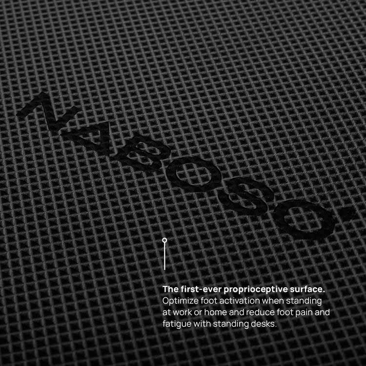 A photo of the Naboso standing mat a textured mat. The mat is black in color and has Naboso written on it. The mat is shown up close to shown the texture and the word Naboso on it. 
