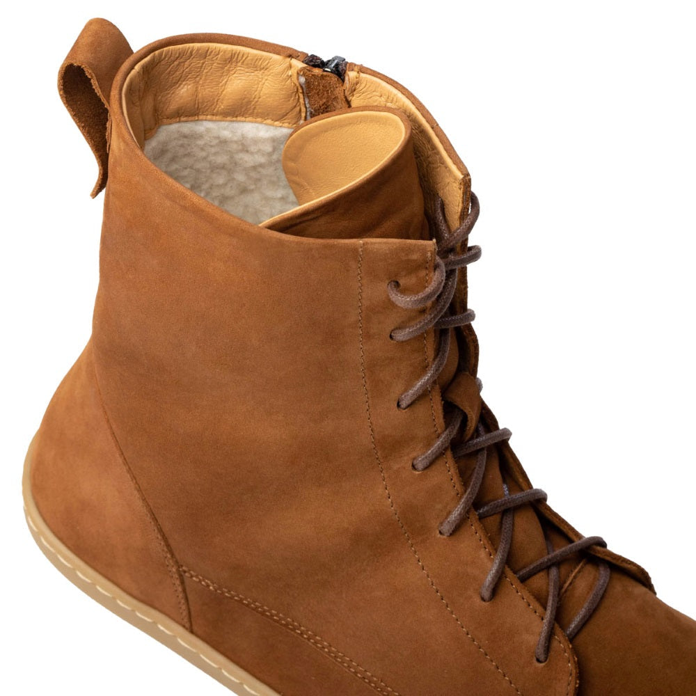 A photo of the Shapen Cozy lace up boots made from a water resistant nubuck leather upper, wool lining, and brown rubber soles. The boots are brown in color with brown laces and have a zipper on the inner side. The right boot is shown from the top focused on the opening of the boot to show the wool lining and the laces up close, on a white background. #color_brown